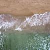 Bølger skyller inn over sandstrand