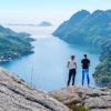 To jenter står og kikker utover en fjord