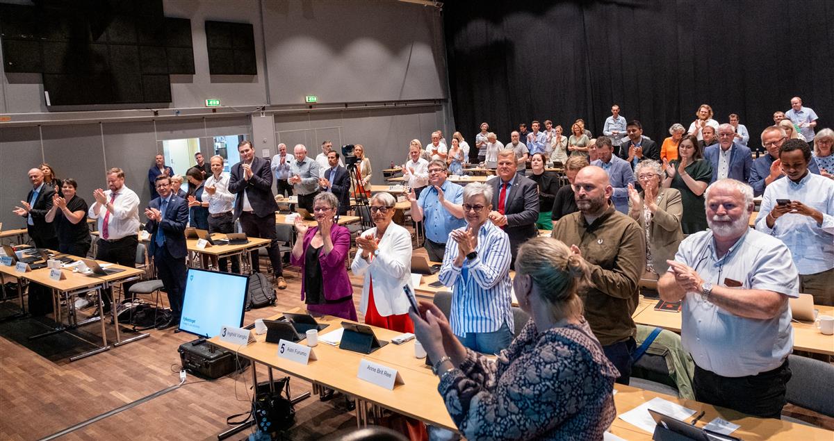 Flere mennesker som står og klapper. - Klikk for stort bilde