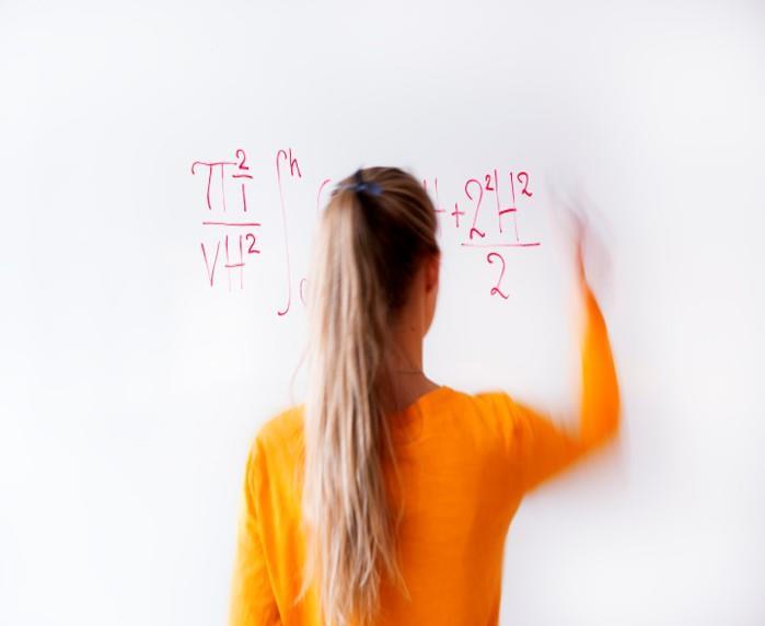 Jente skriver regnestykke på en tavle - Klikk for stort bilde