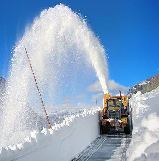 brøytebil som spruter snø bort fra vei - Klikk for stort bilde