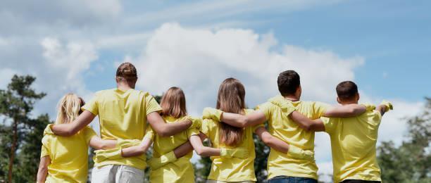 ungdom i gule t-skjorter som holder rundt hverandre - Klikk for stort bilde